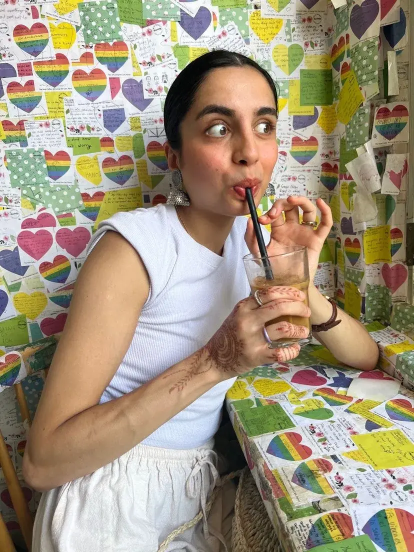 Deeva drinking Cà phê sữa đá (Vietnamese iced coffee) at a cafe in Hanoi
