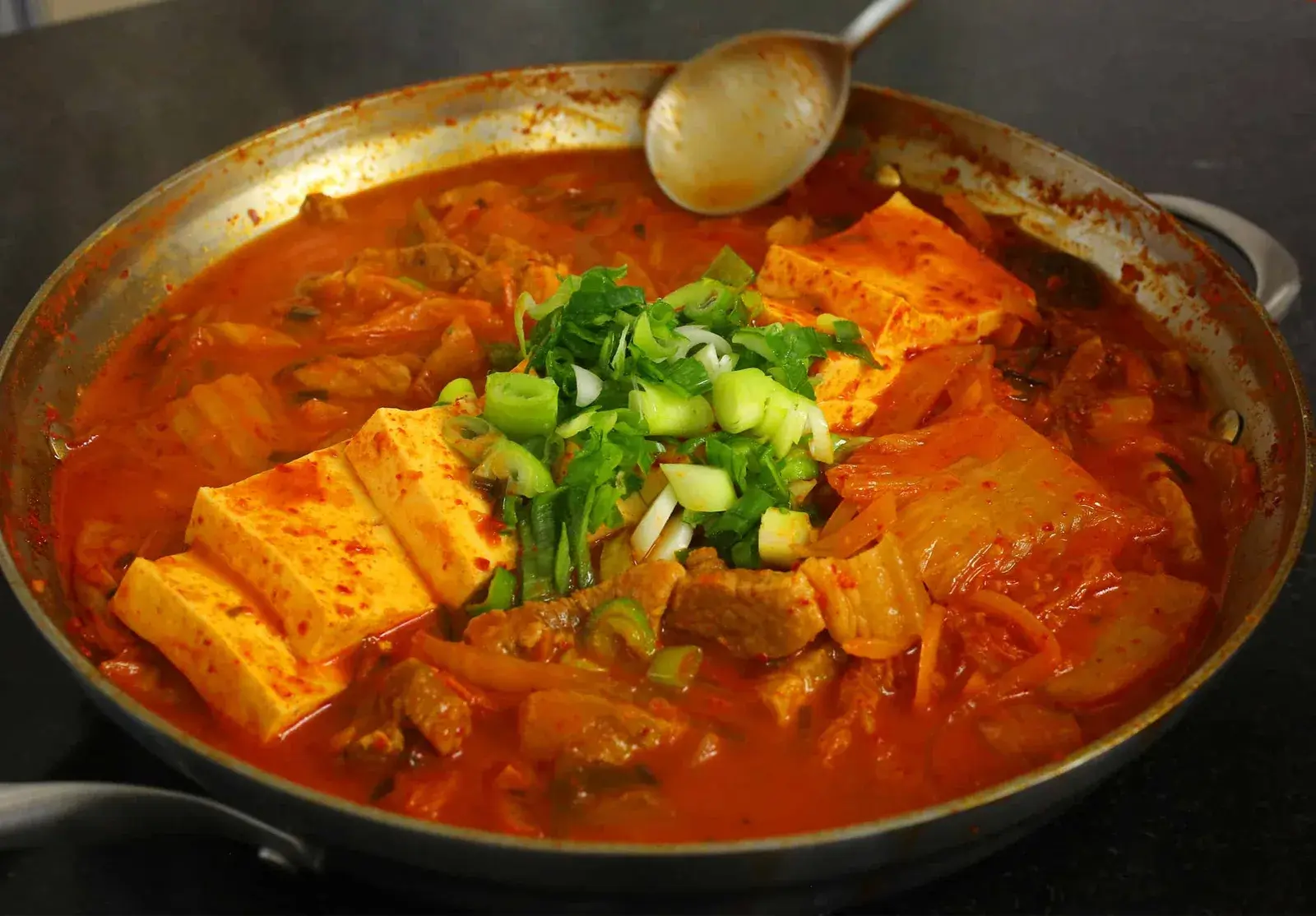 Bowl of boiling red kimchi jjigae stew