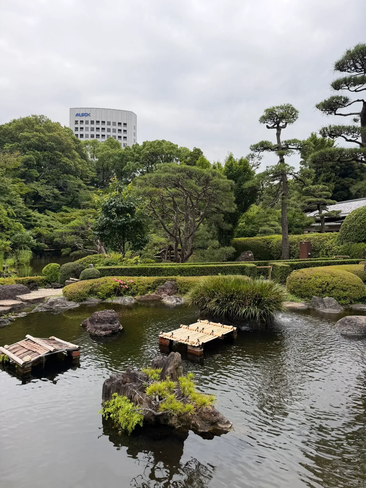 Traditional stone bridge surrounded by greenery at Hotel New Ohtani Japanese Garden in Tokyo
